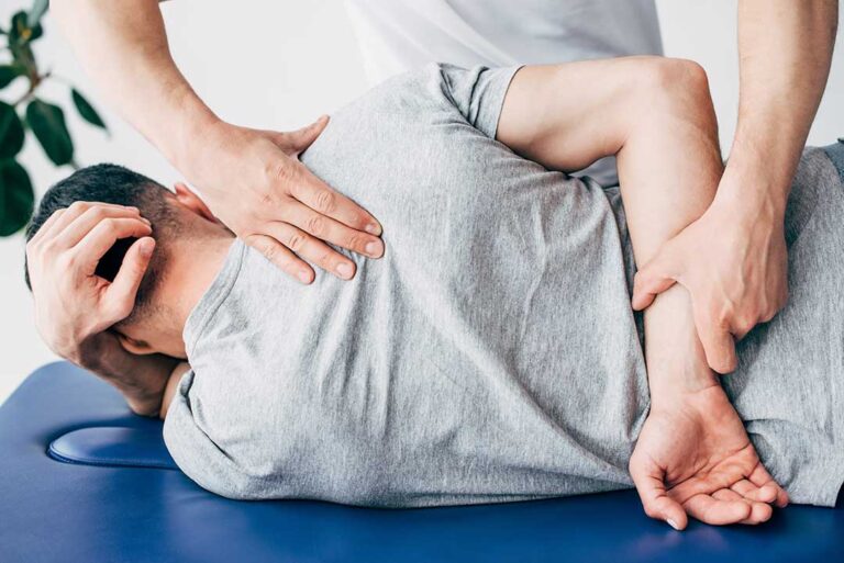 A diverse group of people of different ages stretching together in a bright indoor space.