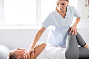 A person receiving a gentle spinal adjustment from a licensed chiropractor in a bright, professional clinic setting.