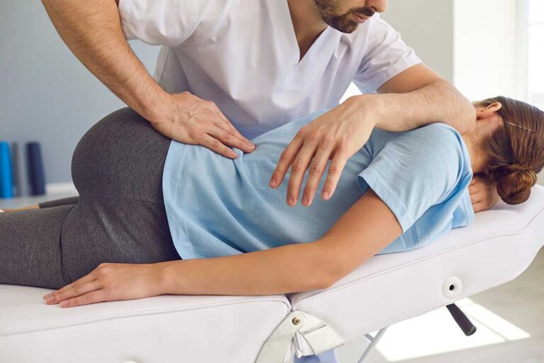 Person resting with a warm compress on the lower back after a chiropractic adjustment.